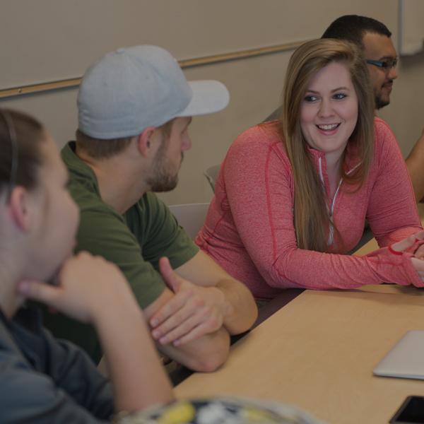 Students talking together in classroom.